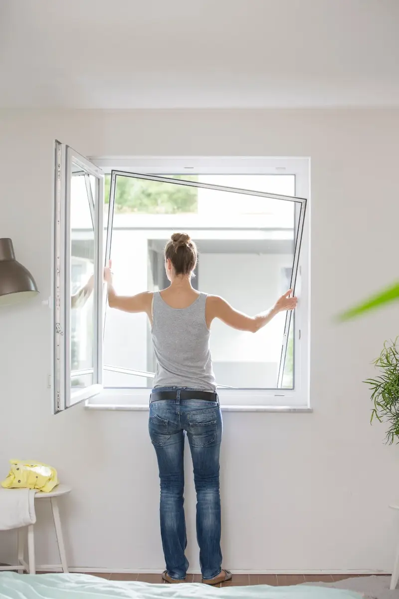 Stefan Köhler montiert einen Spannrahmen am Fenster